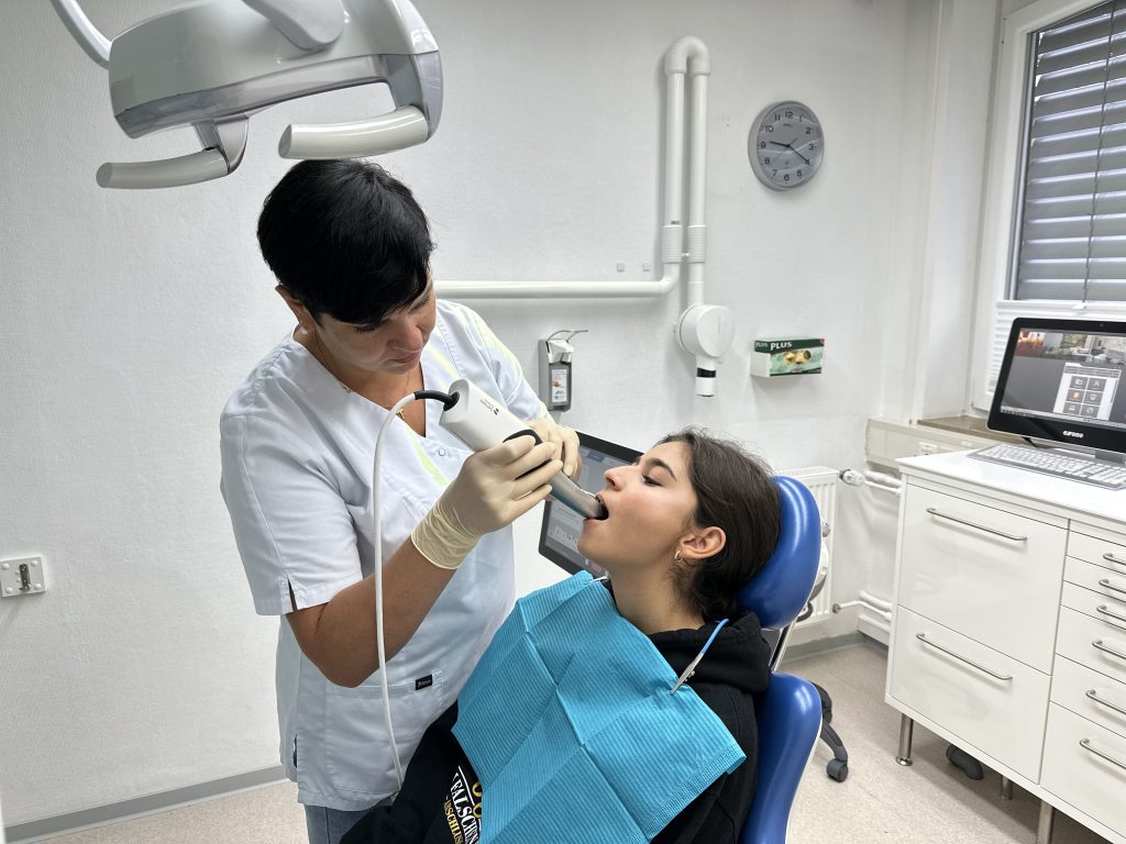 Mitarbeiterin der Praxis nimmt bei einer Patientin einen digitalen Abdruck mit dem Intraoralscanner